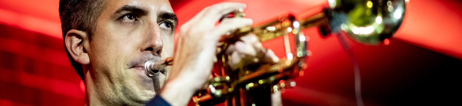 musician intensely blowing in his trumpet (or is that a flugelhorn?)
